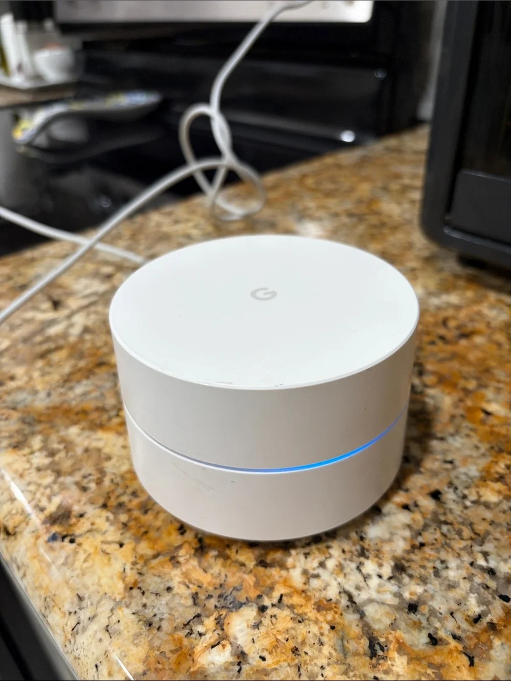 Google mesh Wi‑Fi puck in white with blue LED